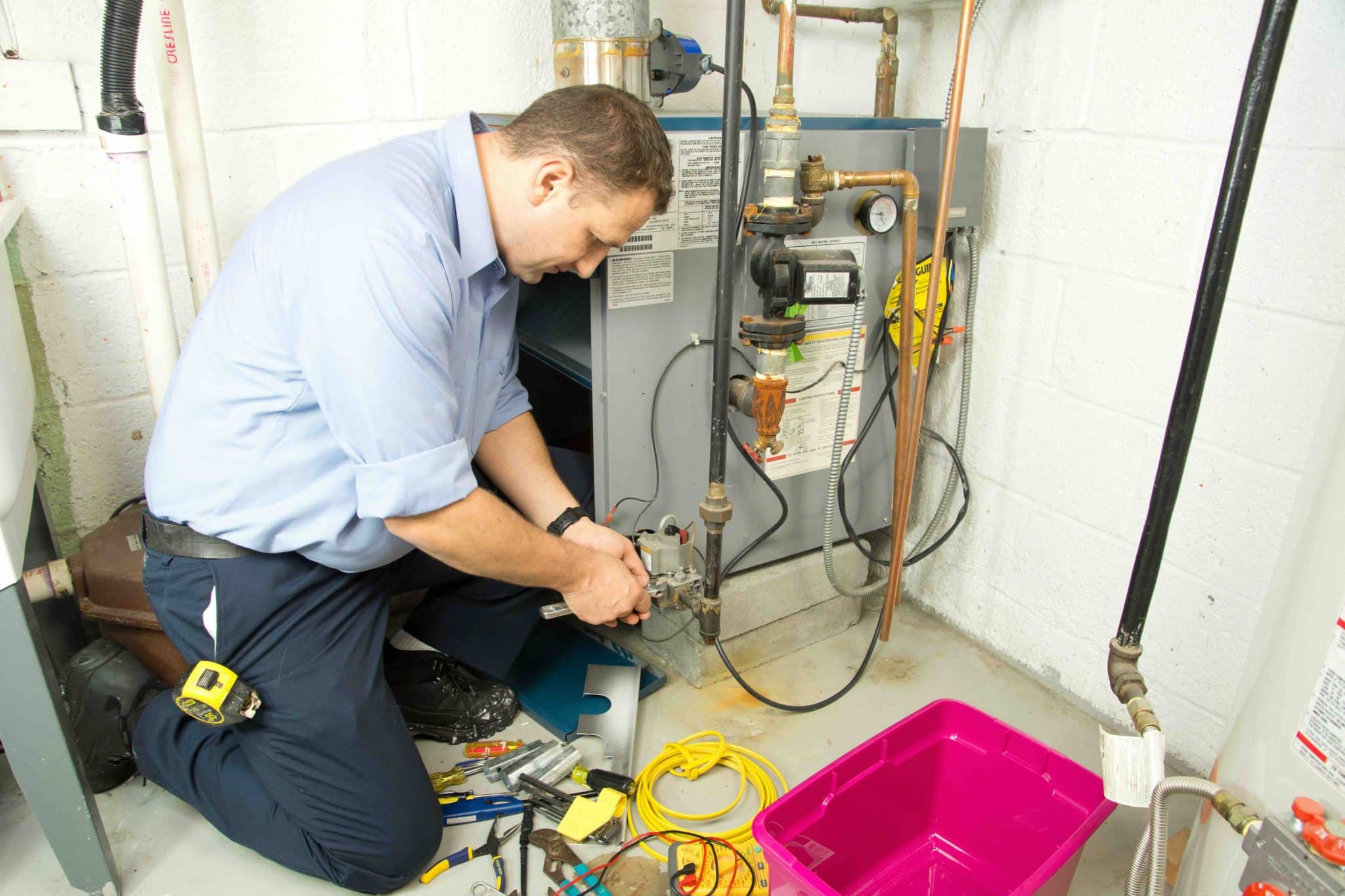  A professional HVAC technician is doing an emergency furnace repair after it goes out in the winter.