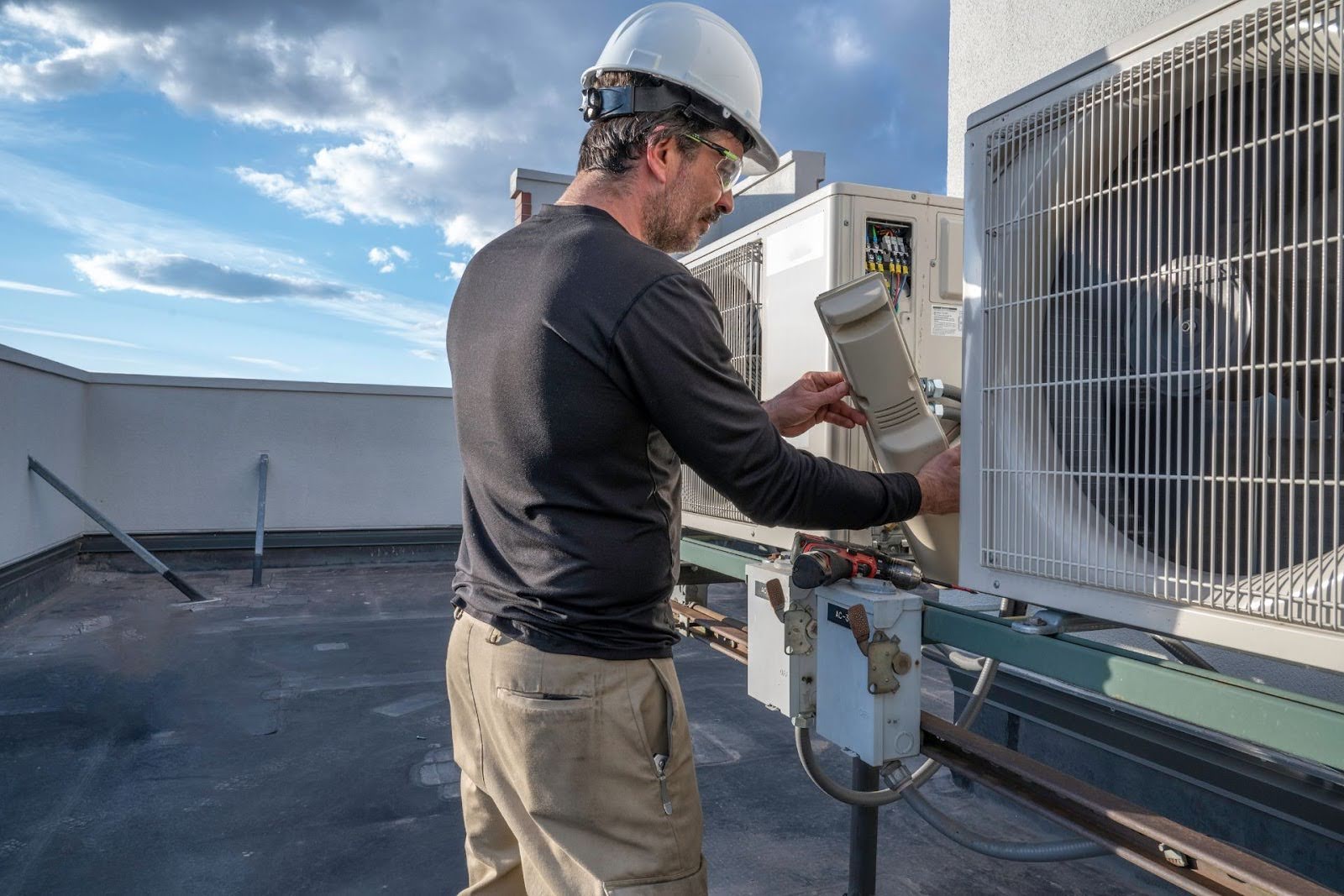 A technician checking rooftop HVAC units.